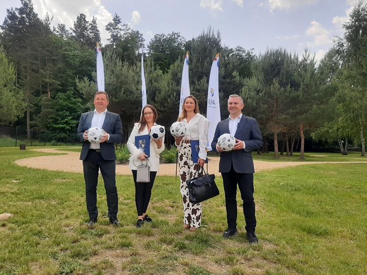 Burmistrz Michał Pasieczny, wiceburmistrz Ariel Sinicki i przedstawicielki firm wykonawczych z podpisanymi umowami i piłkami po konferencji prasowej w Rumi