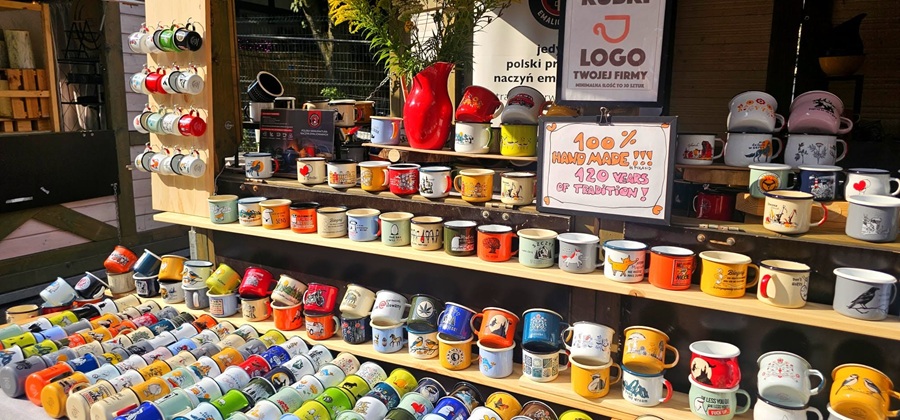 Tabliczka "100% Hand Made" na stoisku z kubkami emaliowanymi